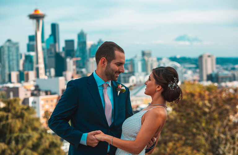 a couple holding each other after engagement with Seattle in the background