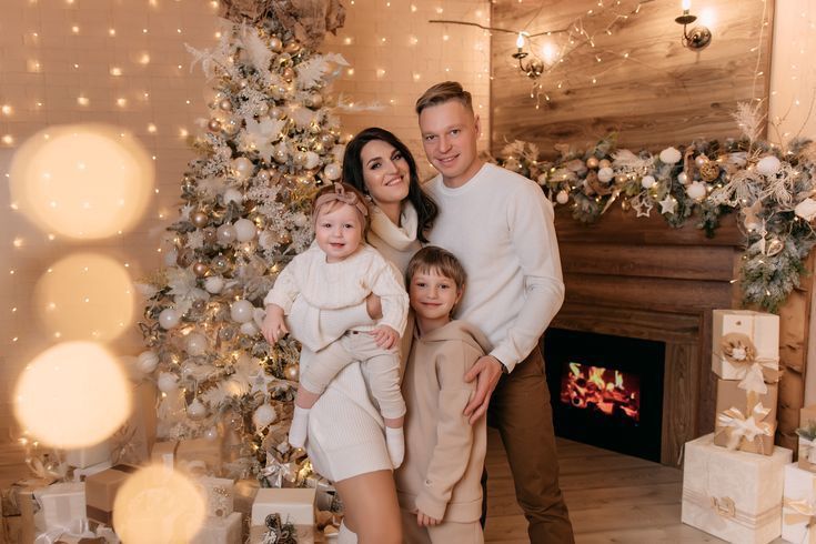 a family standing happily next to a Christmas tree