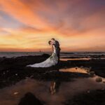 A wedding photo pf couples with the backdrop of sunset