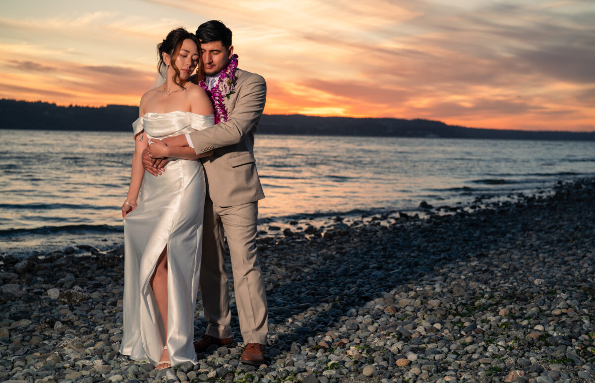 A couple standing on the shore in the golden time.