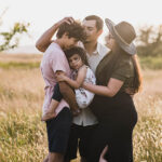 A family portrait in a field at golden hour