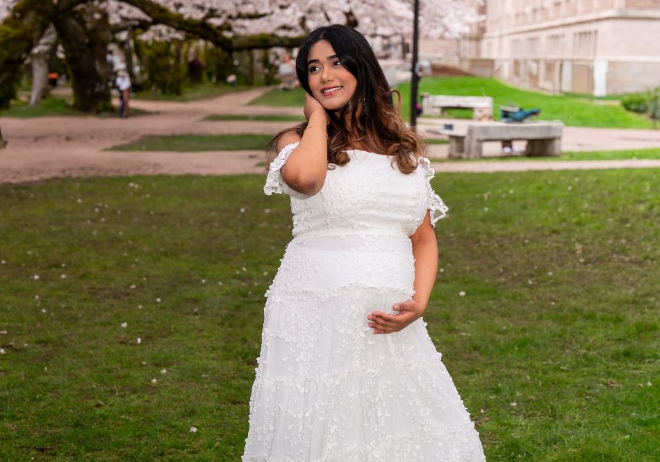 A pregnant lady posing in front of the camera for her photoshoot