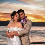 Wedding photo of a couple holding each other with a sunset backdrop