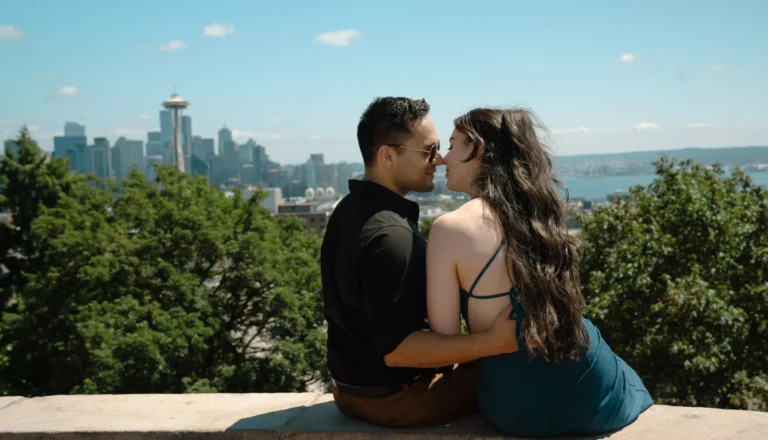 a couple kissing in a view of Seattle city