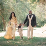 a family of three walking outside in a garden