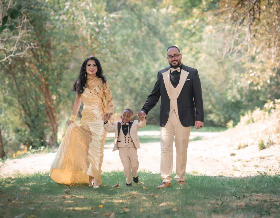 a family of three walking outside in a garden