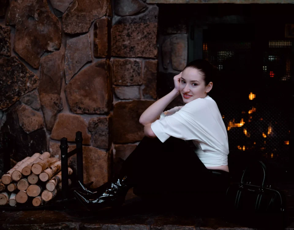 portrait of a girl sitting next to a fireplace
