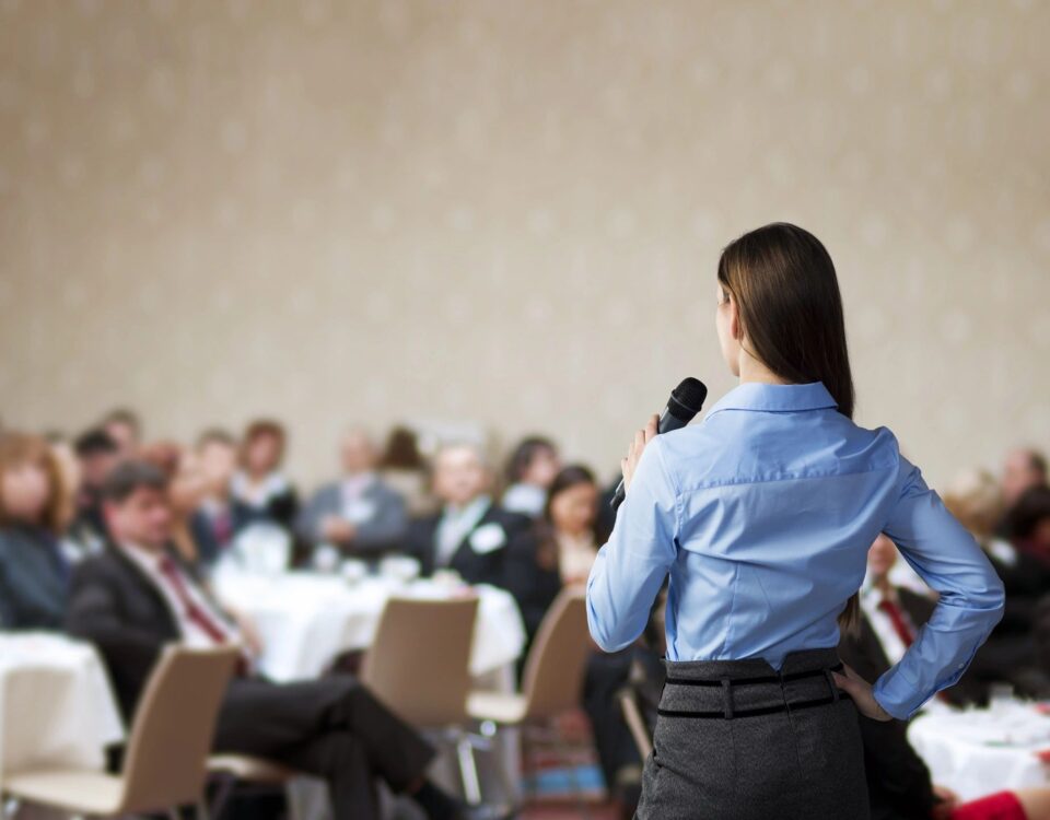 A woman lecturing for a group of people