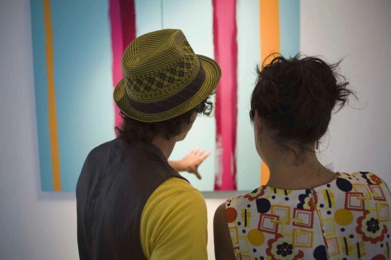 Two people staring at an art work in an art gallery