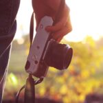 A man holding a vintage camera in his hand