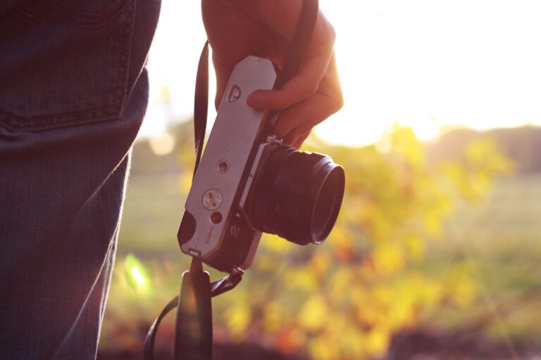 A man holding a vintage camera in his hand
