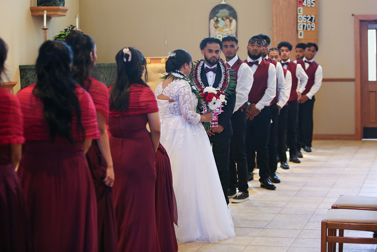 A wide photo of the bride and the groom with their companies.