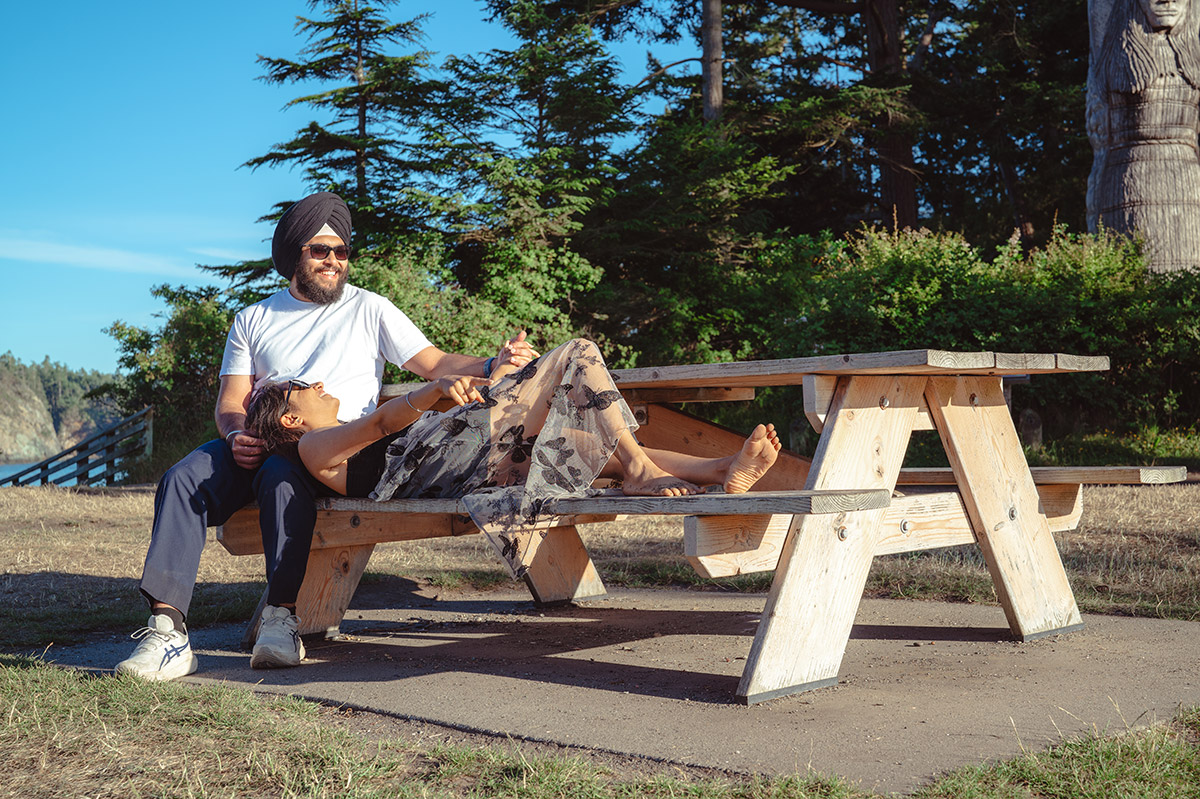 A girl laid on a bench next to her partner 