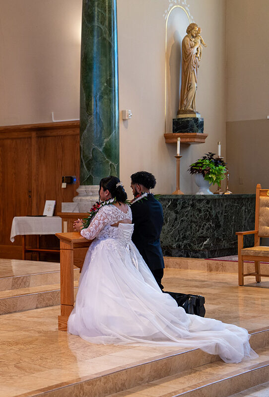 Wedding picture of a couple kneeling in the church