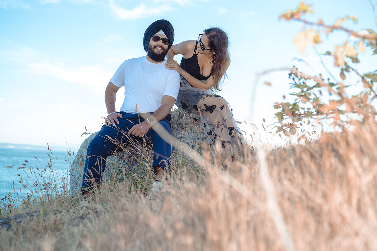 a couple sitting on a rock next to each other