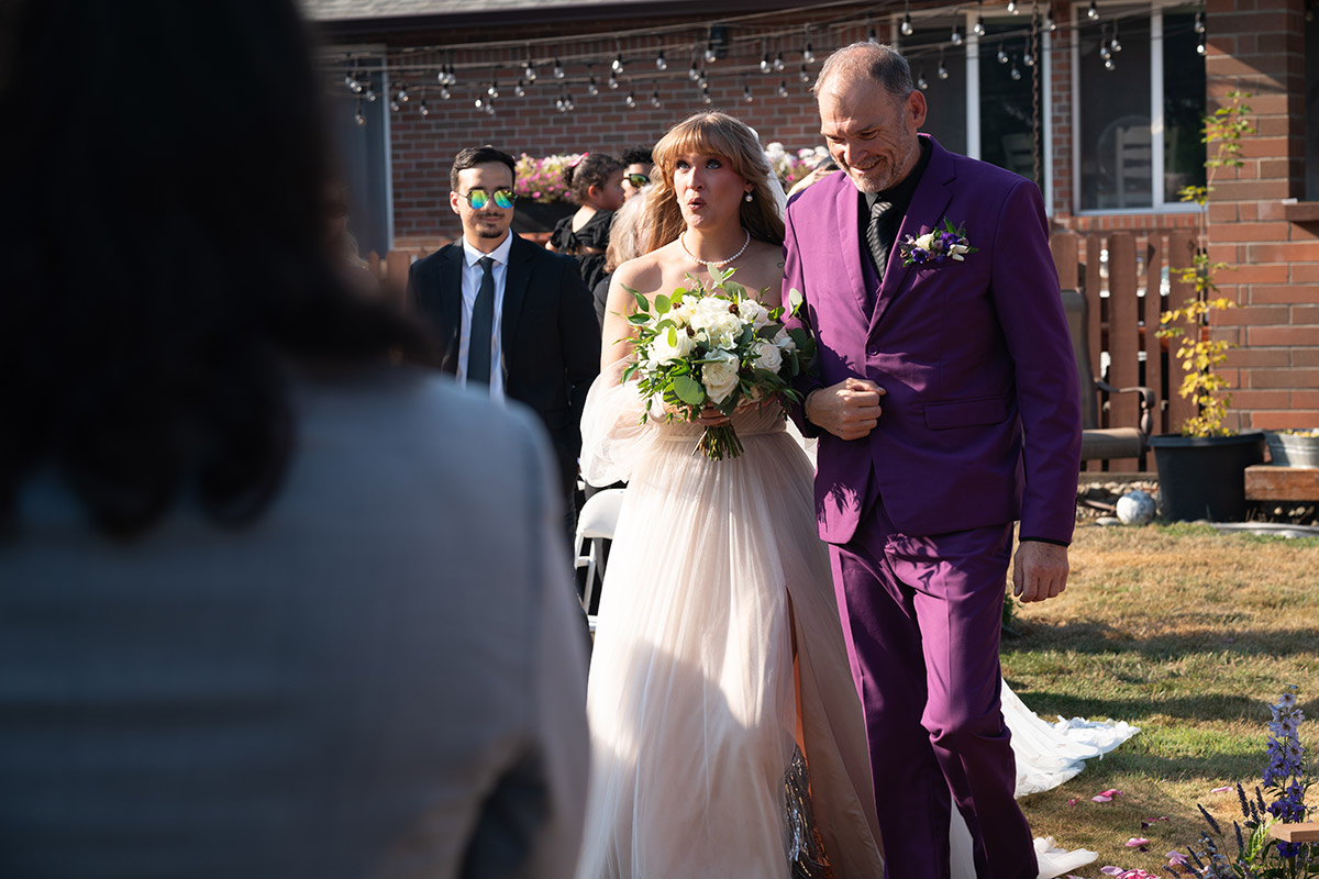 The bride is walking down the isle with her father.