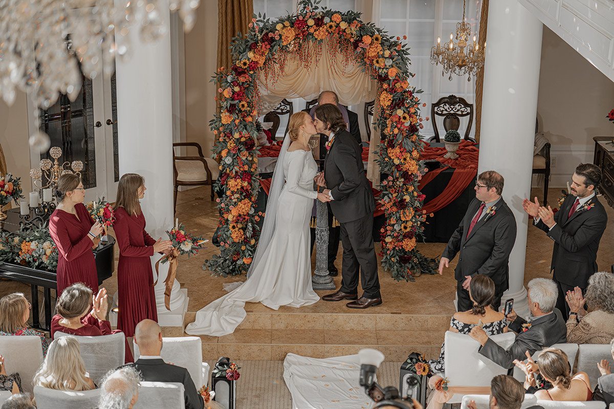 The bride and the groom are kissing each other on their wedding day.