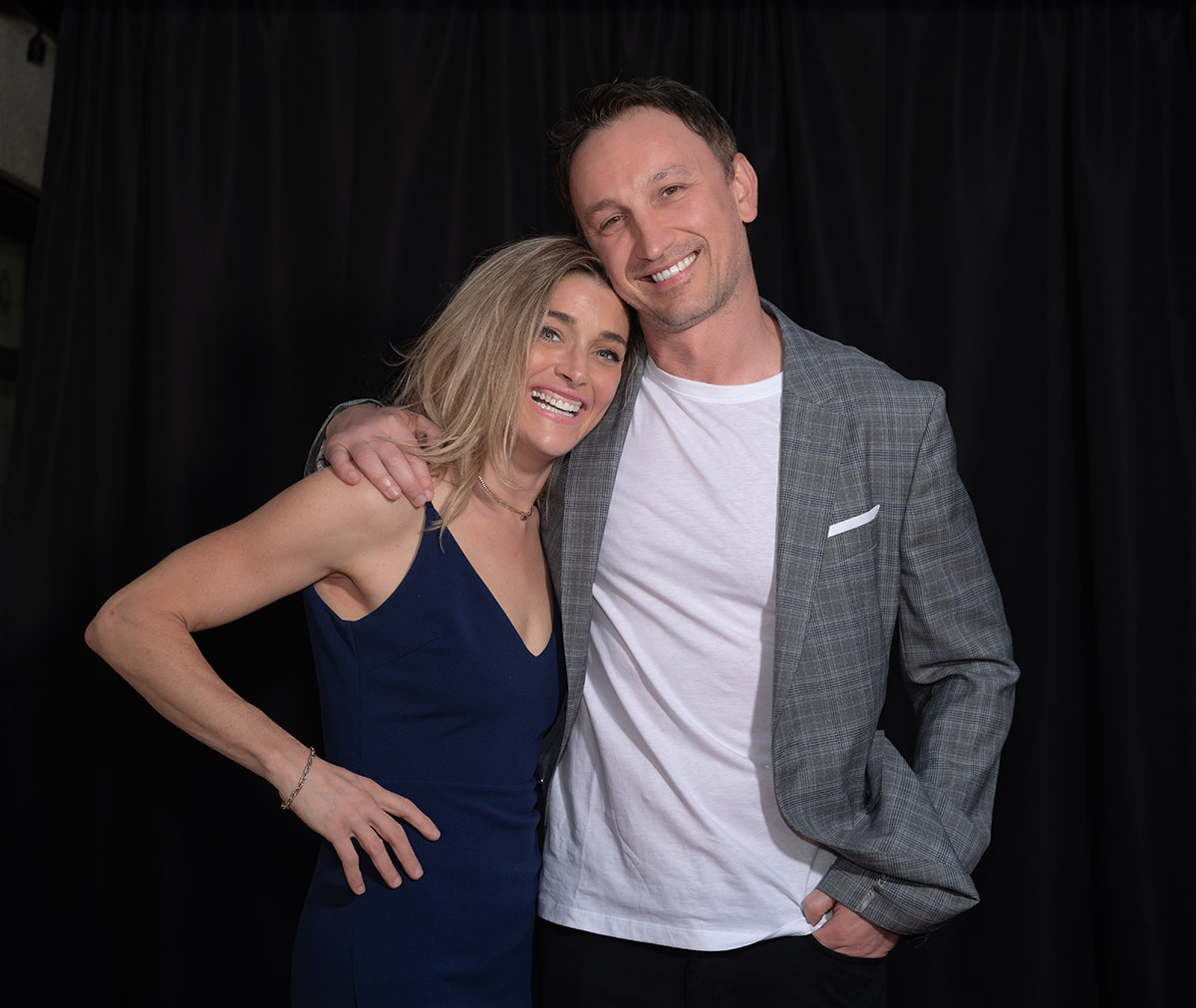A couple standing on red carpet 