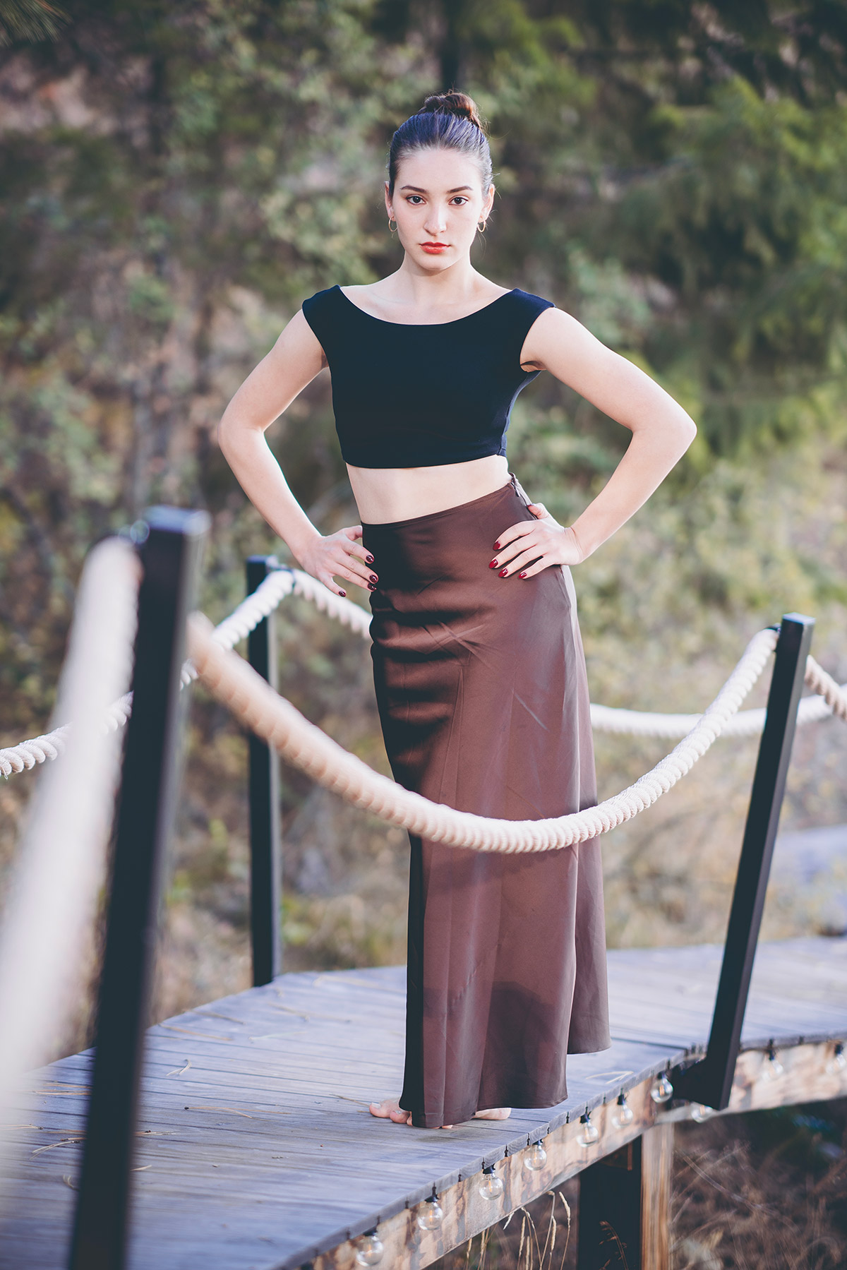 Portrait photo of a girl with white dress and  skirt standing on a bridge