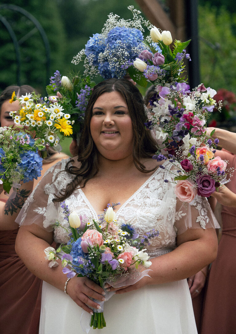 A portrait of the bride with a beautiful and full of flowers backdrop